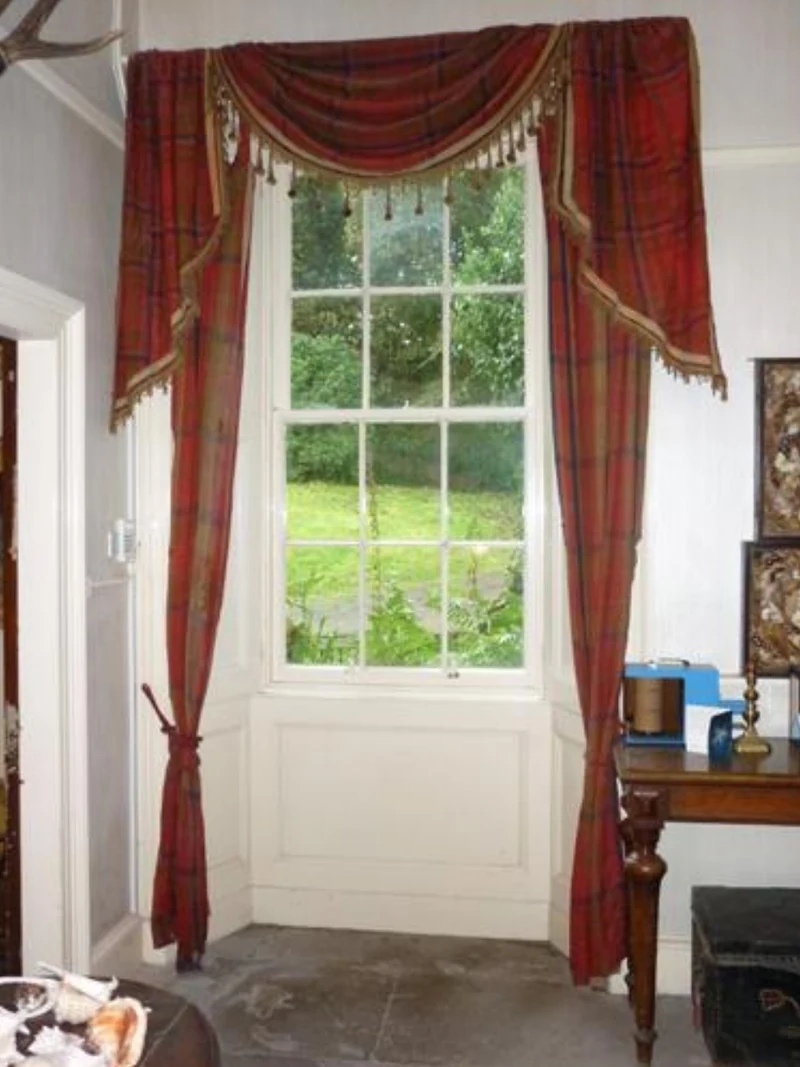 Original Dalriada tartan curtains hanging at Dunollie House, Oban, Scotland — circa 1730 plaid recycled into curtains during the Highland Revival